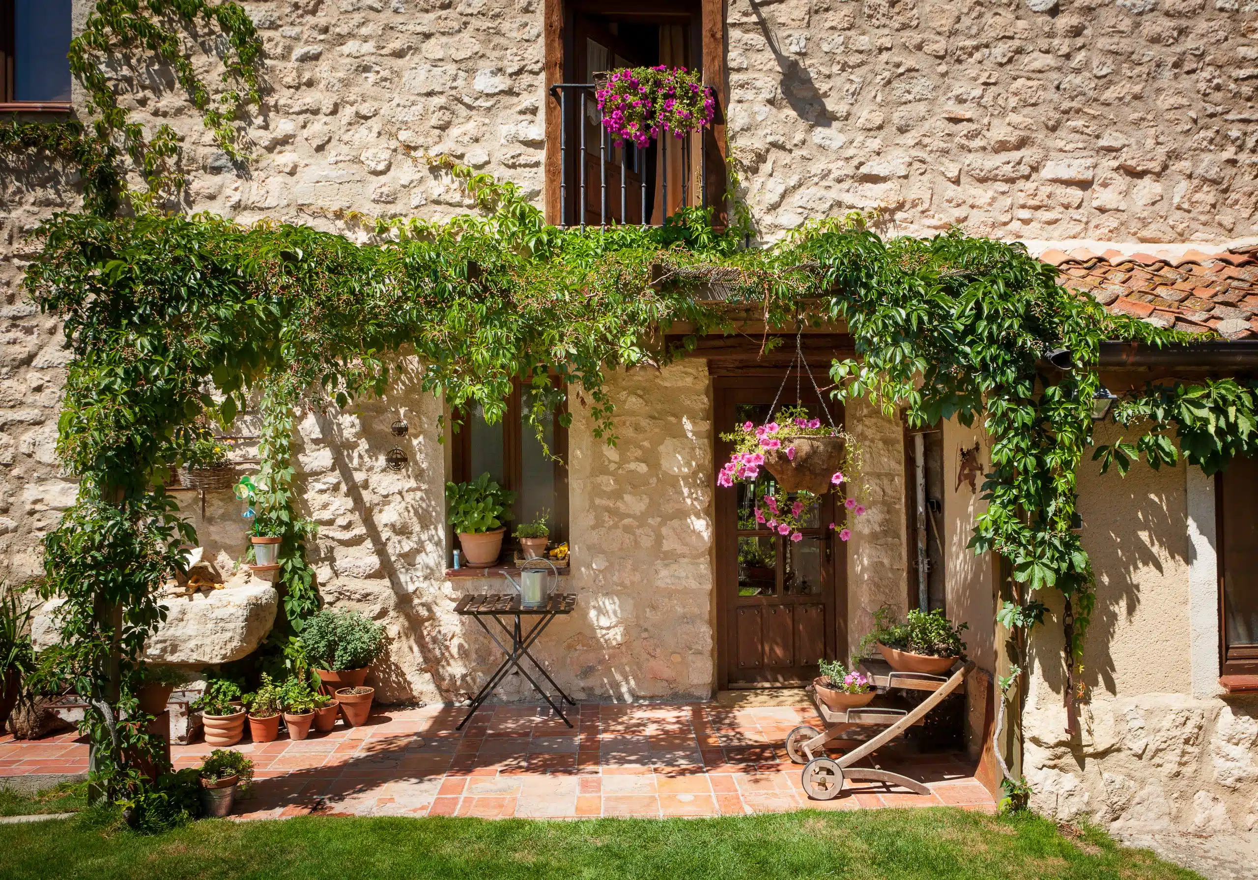 beautiful patio of house with green foliage 2025 04 03 23 07 48 utc scaled 1 Jardín decorado con plantas y muebles con materiales naturales como la madera.